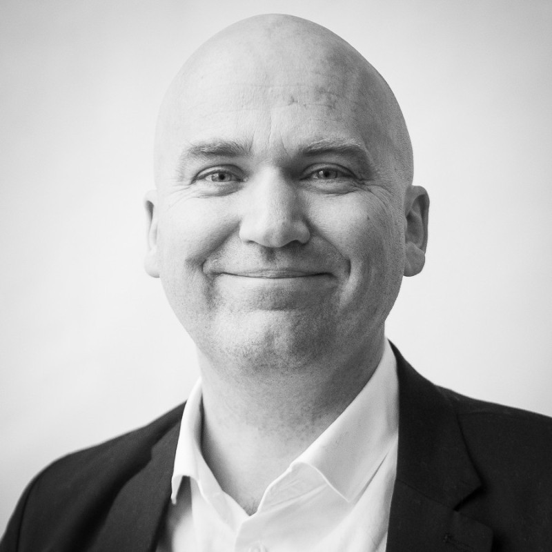 Black and white close-up portrait of a man in a suit.