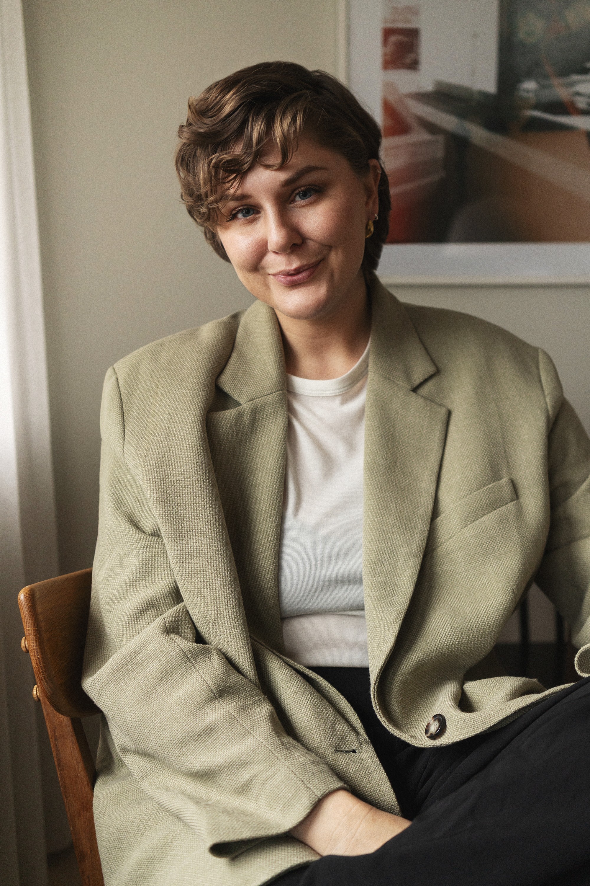 Frida sitting on a wooden chair, smiling at the camera.